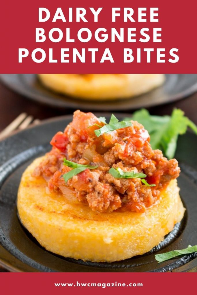 Turkey ragu Bolognese sauce over grilled polenta appetizers on a black bowl.