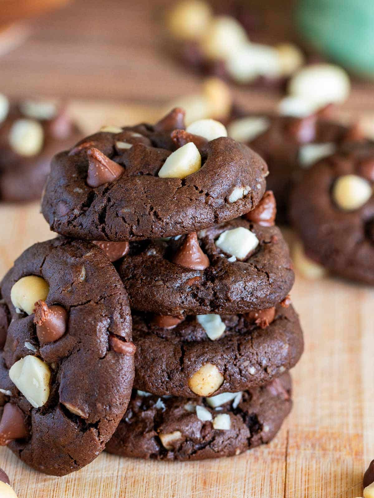 Stacked macadamia nut cookies with tea in the background. 