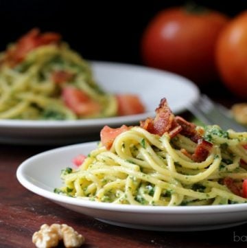 Spinach pesto pasta topped with bacon.