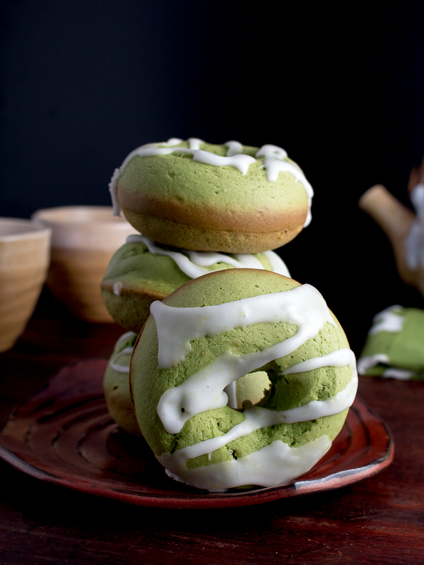 Baked Matcha Lemon Glazed Donuts stacked up and freshly baked.