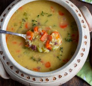 Spoonful of delicious curried lentil soup in a beige soup bowl.