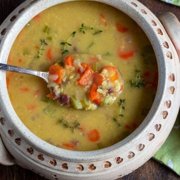 Spoonful of delicious curried lentil soup in a beige soup bowl.