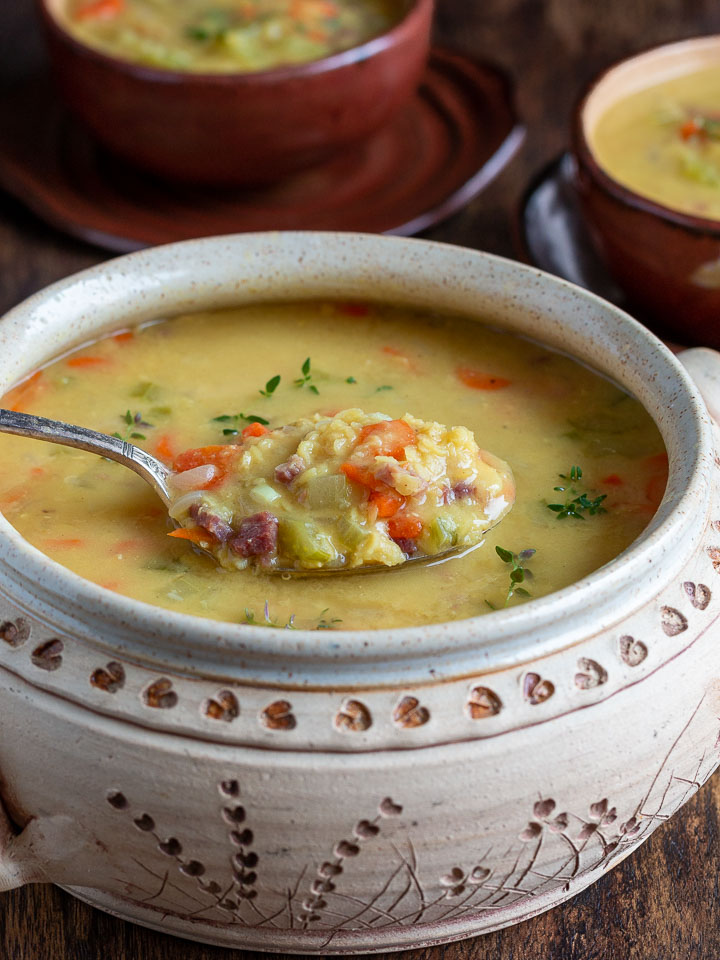 Soup is ready to be served in a beige soup bowl. 