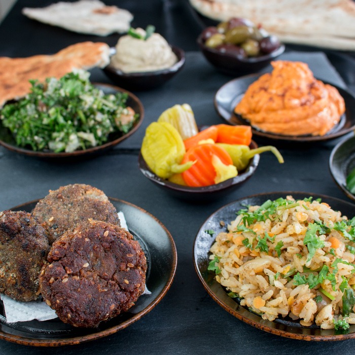 Close up of the falafel showing the sesame seeds and the rice with other pickled vegetables in the shot. 