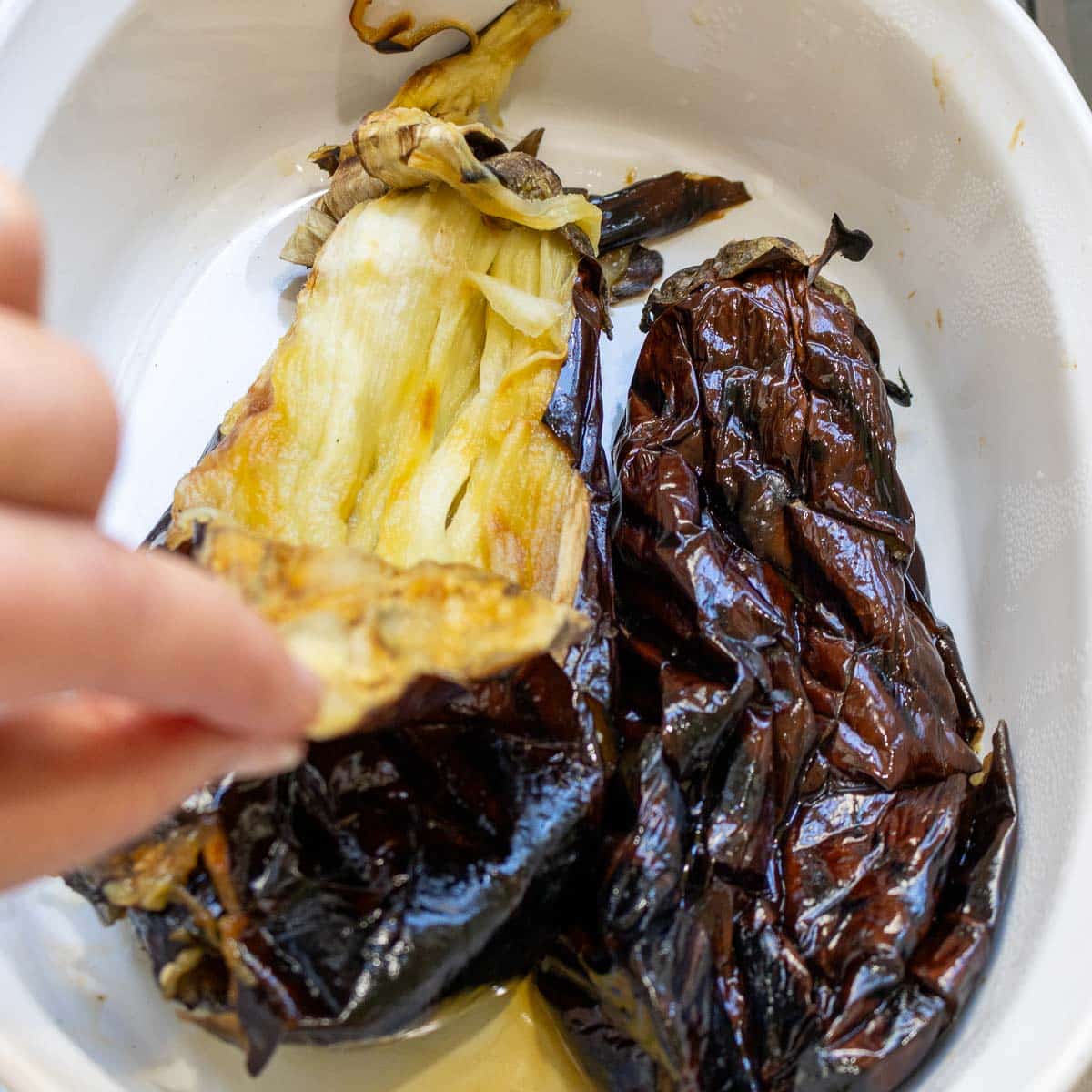 Peeling the eggplant and noting there is only a couple of tablespoons of liquid left in the bowl after steaming.