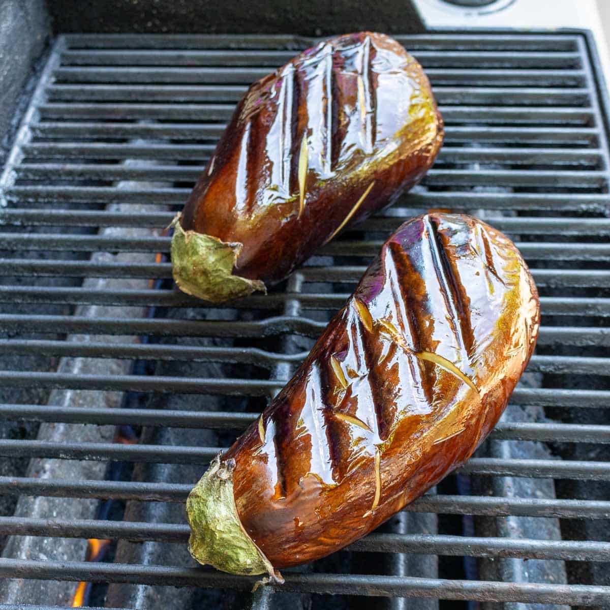 2 eggplants on the outdoor bbq grill with grill marks.