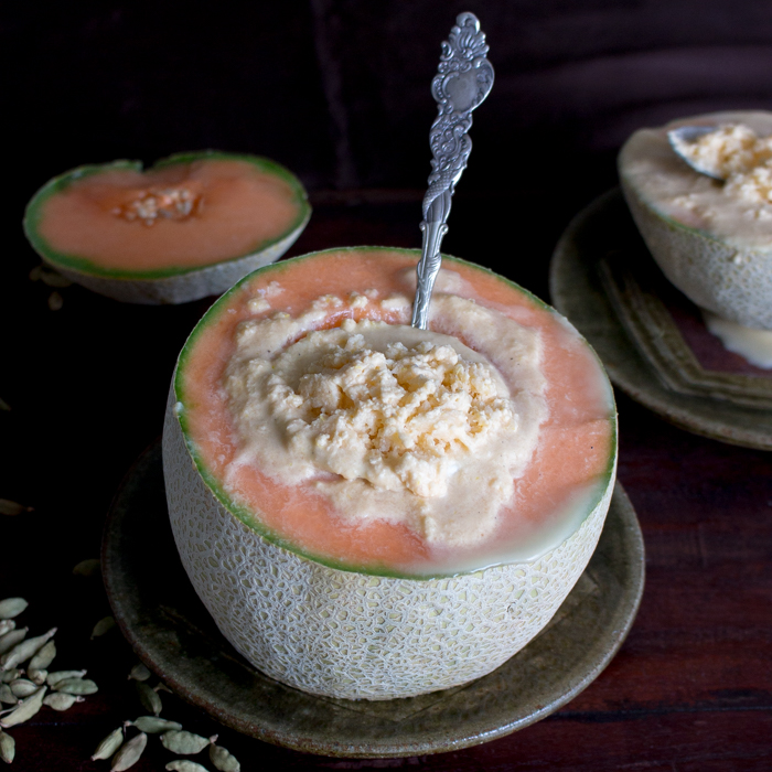 3 cantaloupes with one with sorbet inside and it is starting to melt.