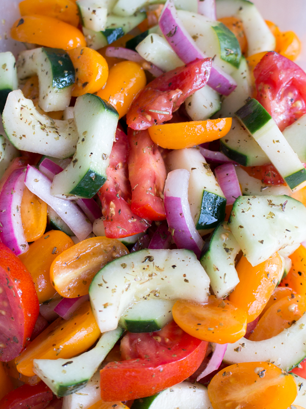 Salad getting tossed with the vinaigrette. 