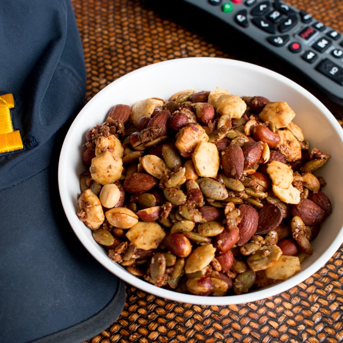 spiced nuts with a u of m hat and remote control on the table.