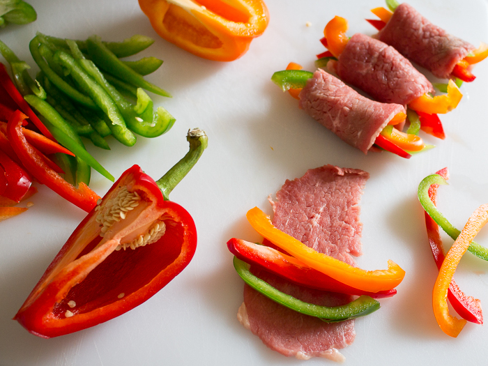 Demonstrating rolling up beef around peppers