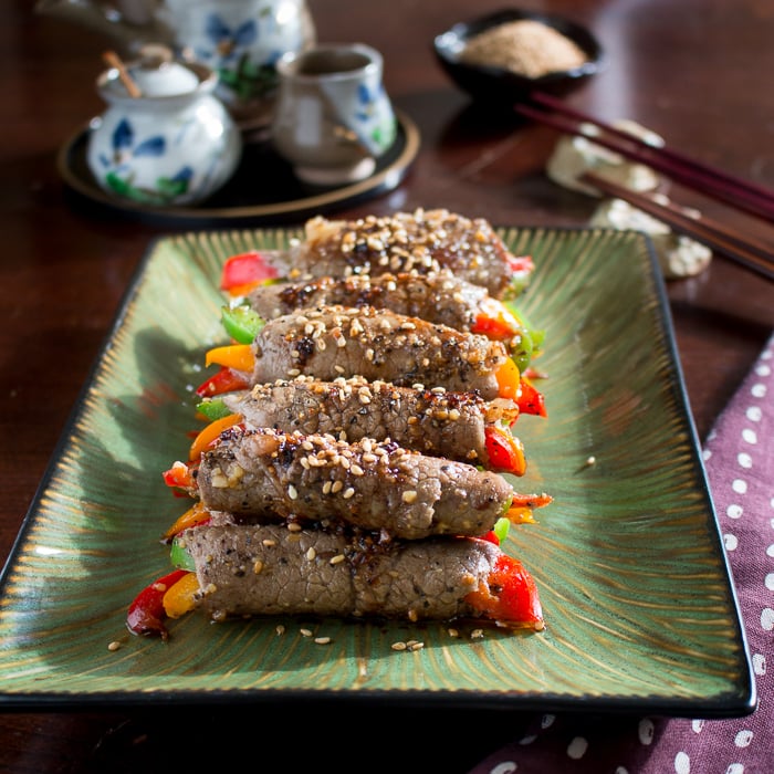 Beef wrapped around peppers on green plate