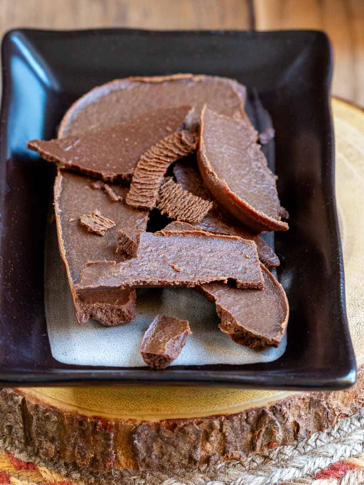 Easy 3 ingredient vegan chocolate on a brown and white plate.