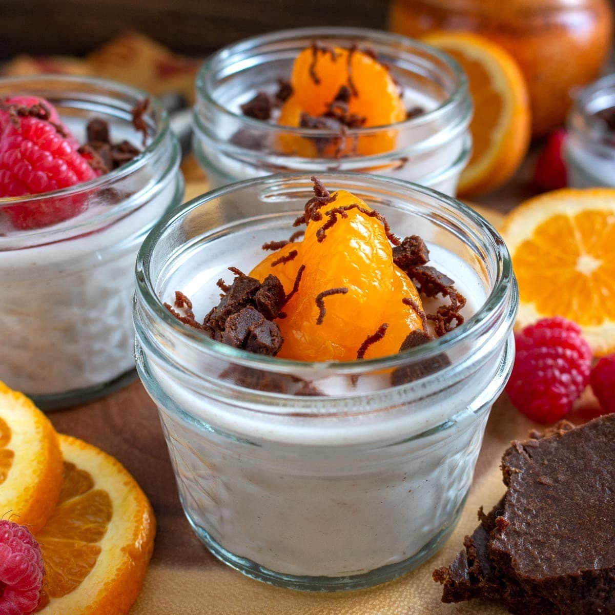 Close up shot of creamy chai spiced coconut jelly with plump mandarin oranges and shavings of chocolate.