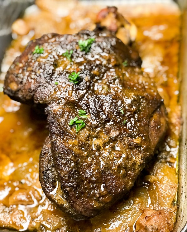 Browned whole semi- boneless leg of lamb cooked and resting in pan juices