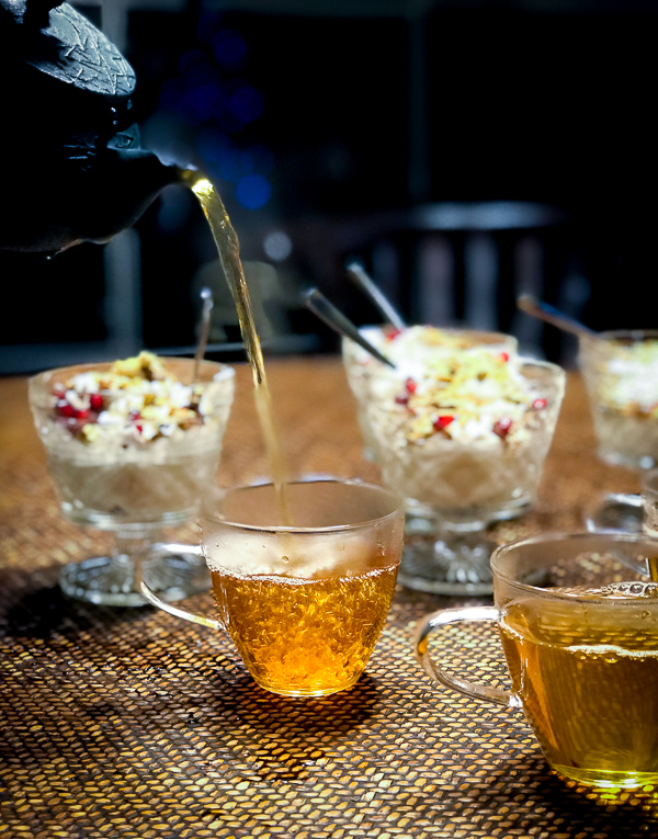 Healthy Moroccan Mint Tea being poured high into cups with desserts on table