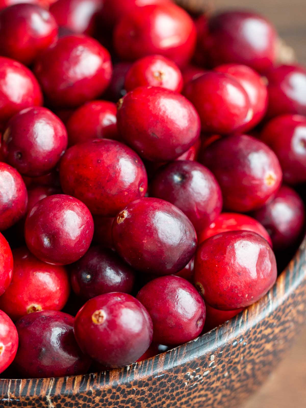 Fresh cranberries in a wooden bowl. 