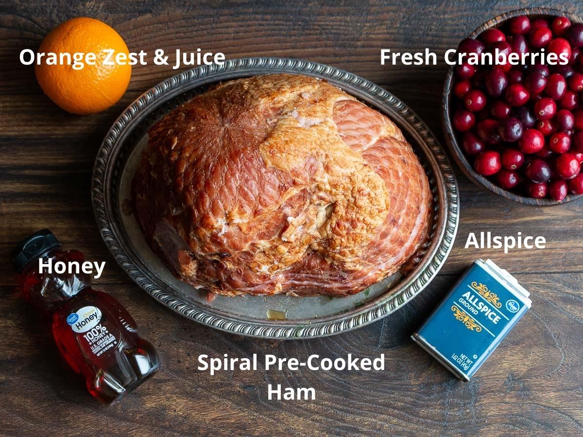 Ingredients to make a holiday ham laid out on a wooden board.
