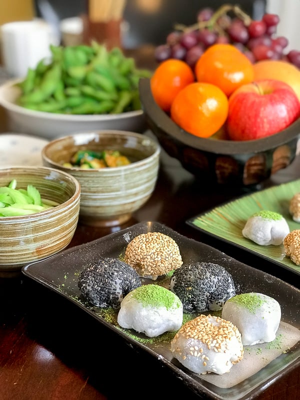 Mung Bean Daifuku Mochi on Japanese potter plates decorated with matcha green tea and sesame seeds.