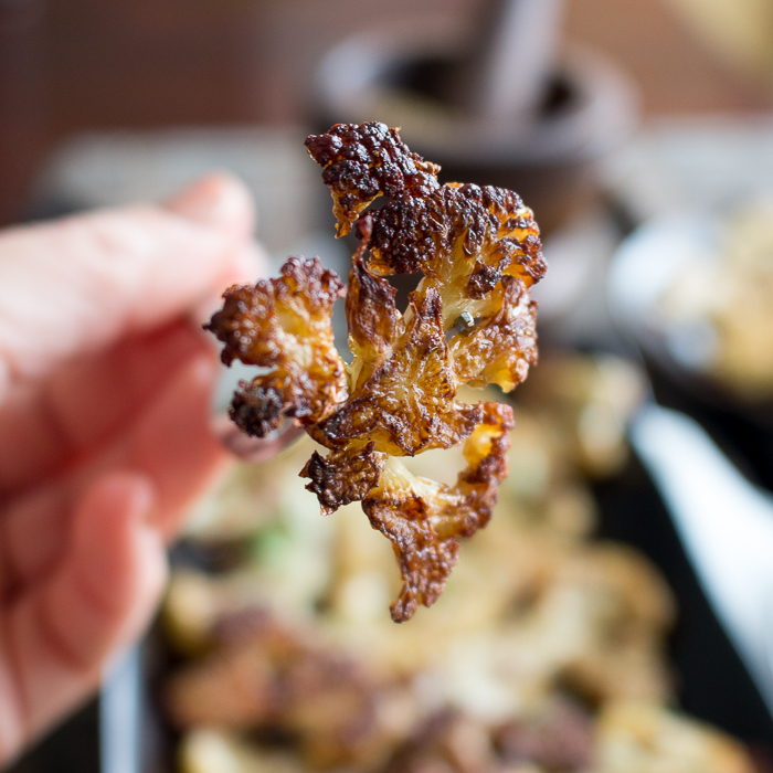 Holding a super crispy cauliflower piece in our fingers showing how caramelized the ends get. 