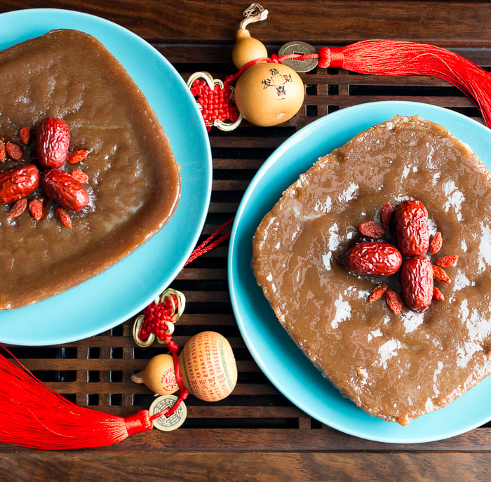 2 nian gao on blue plates garnished with red dates and goji berries.
