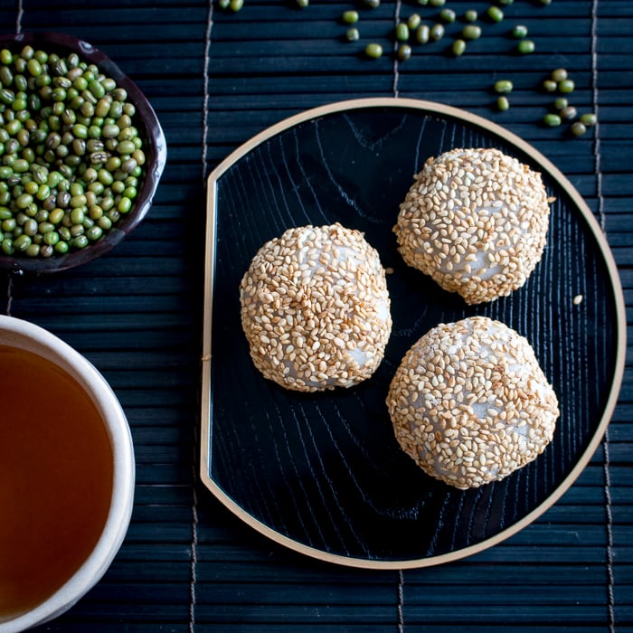 Mung Bean Daifuku Mochi served with tea on a black plate.