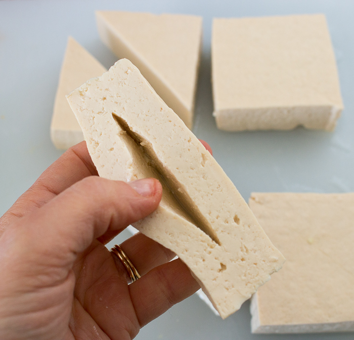 Making a slit into the middle of the tofu to make room for the shrimp filling.