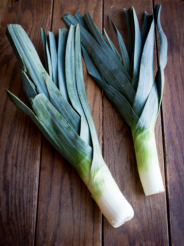 2 leeks on a brown table.