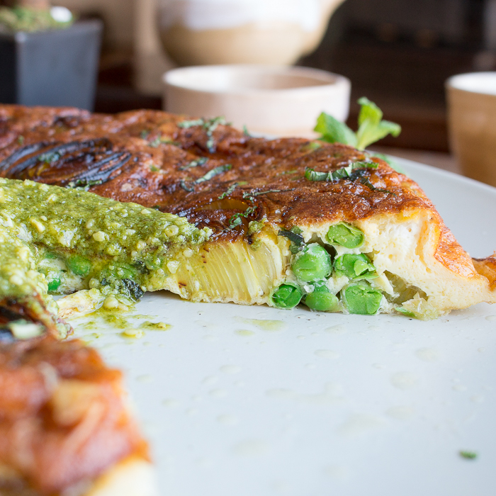 Super cool shot showing a slice out of frittata showing the leeks and vegetables. 