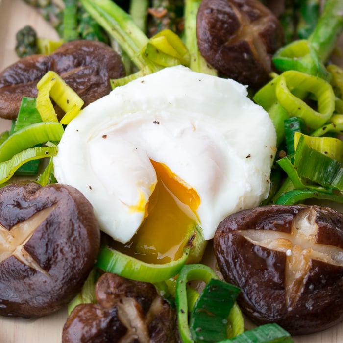 Poached egg cut open and the drippy egg running over the mushrooms, leeks and asparagus. 