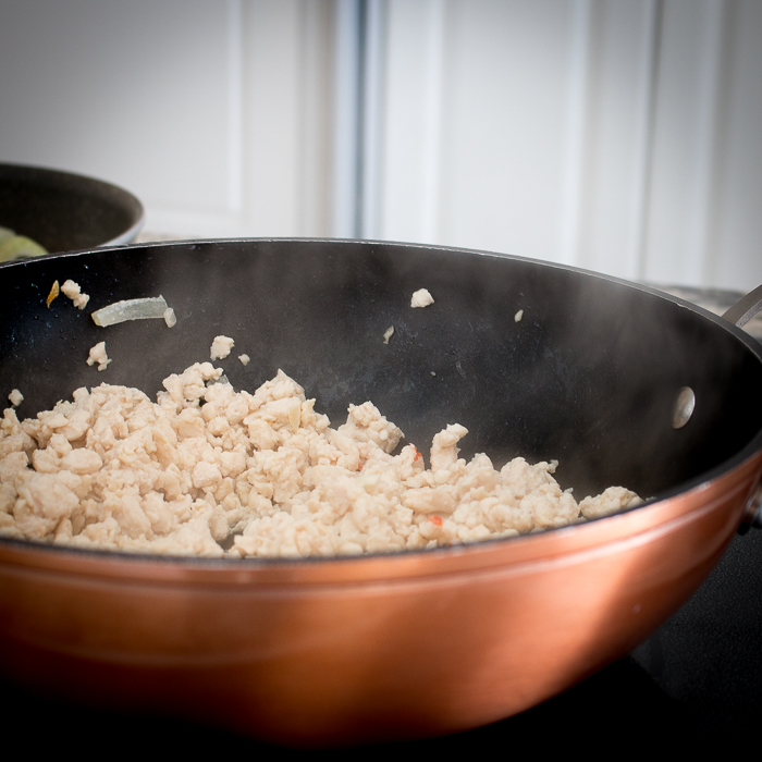 Chicken stir frying in a wok.