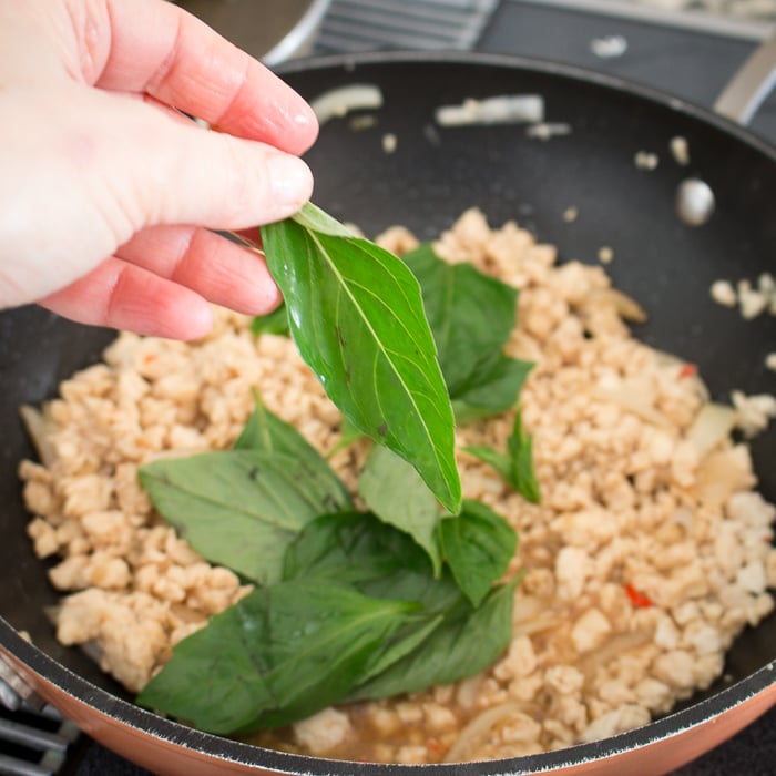 Adding Holy Basil to the chicken stir fry. 