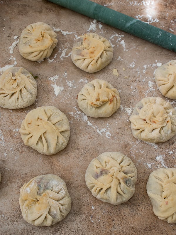 Dim sum formed into little disks on a cutting board with a Chinese rolling pin. 