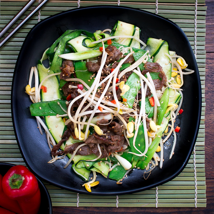 Top down photo showing all the vegetables and topped with sesame seeds and red chilis.