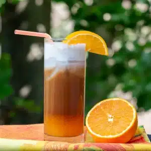 Iced bumblebee coffee with a layer of mocha, orange juice and a frothy dairy free foam on top.