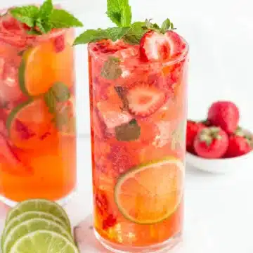 strawberry mojito mocktail garnished with fresh strawberries and mint.