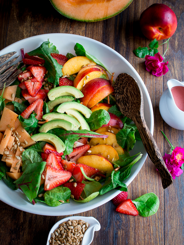 Vegan fruit salad tossed with strawberries, cantaloupe, nectarines and avocado. 