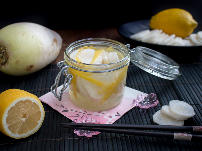 Whole daikon and lemons with a jar of pickles.