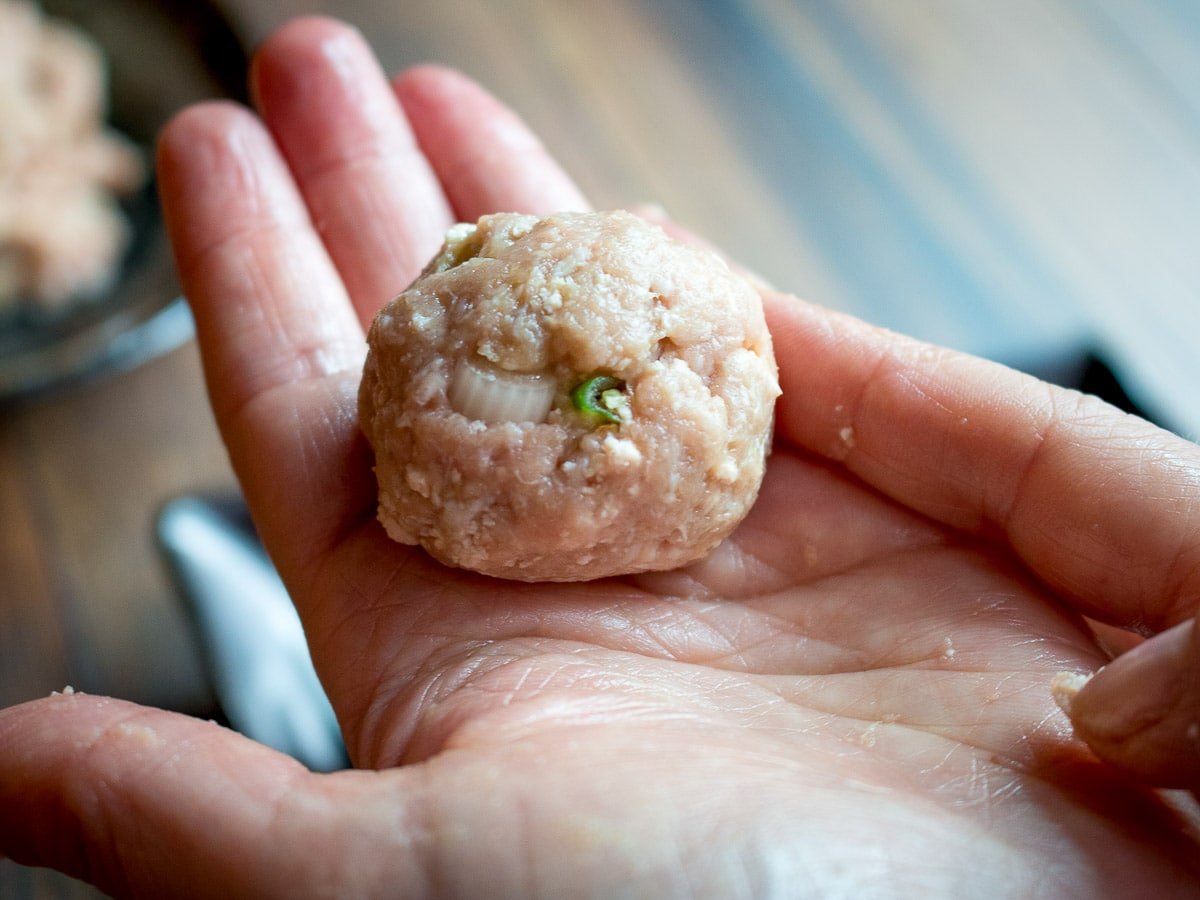 rolling Asian turkey meatballs into balls in a hand. 