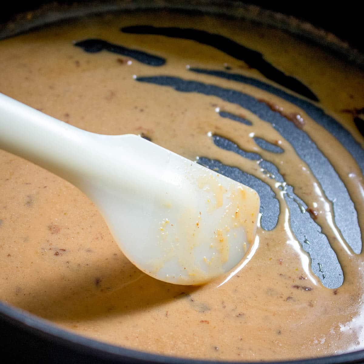 Stirring the coconut red Curry Sauce in a pan. 