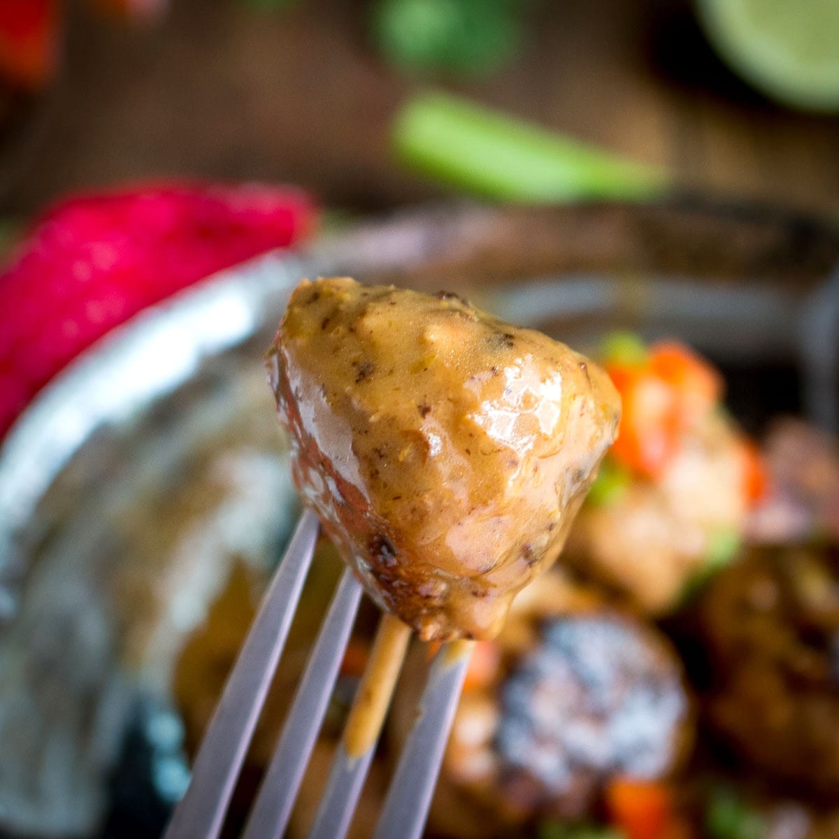 Taking a bite of a Thai turkey tofu meatballs dipped in the curried sauce. 