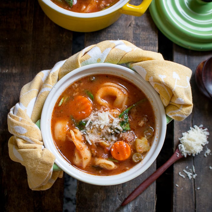 Instant Pot Italian Sausage Tortellini Soup in a shite bowl with a yellow napkin