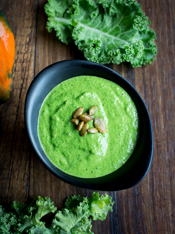 Top down shot of bright green kale pesto with roasted pepitas.