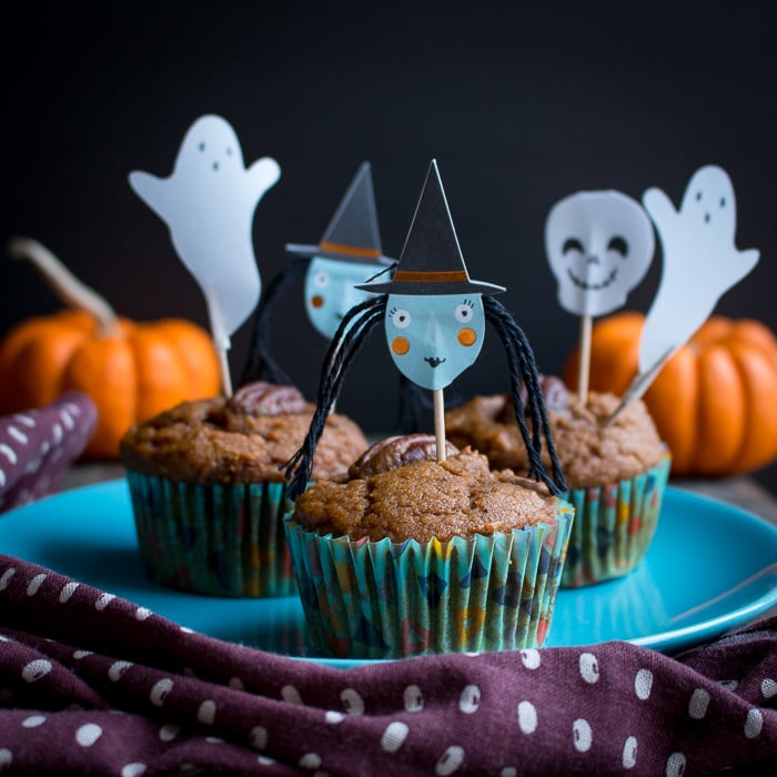 Muffins adorned with fun Halloween characters on little sticks.