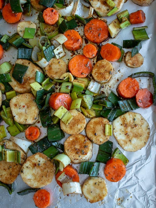 Root vegetable such as parsnips and carrots on a baking sheet. 