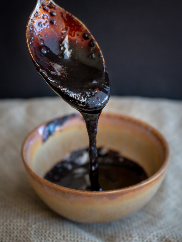 Thick Balsamic Glaze pouring into small brown dish. 