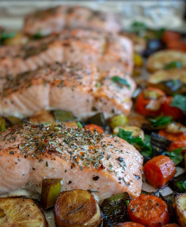 Baked salmon and veggies on a baking sheet. 