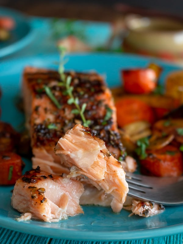 Bite shot showing the super flaky and succulent salmon on a fork. 