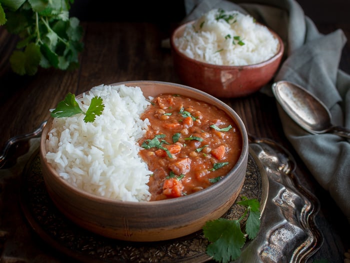 Instant Pot Lentil Ham Stew garnished with parsley and served with rice.