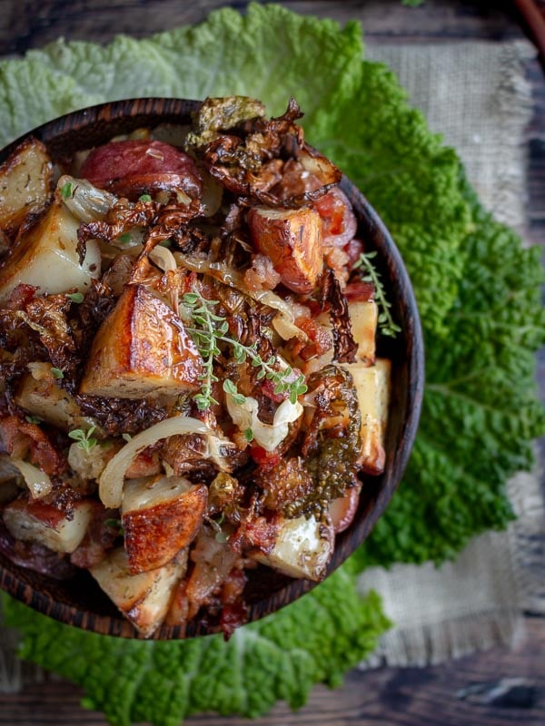 Crispy Roasted Red Potatoes and Cabbage  in wooden bowl garnished with thyme and savvy cabbage,