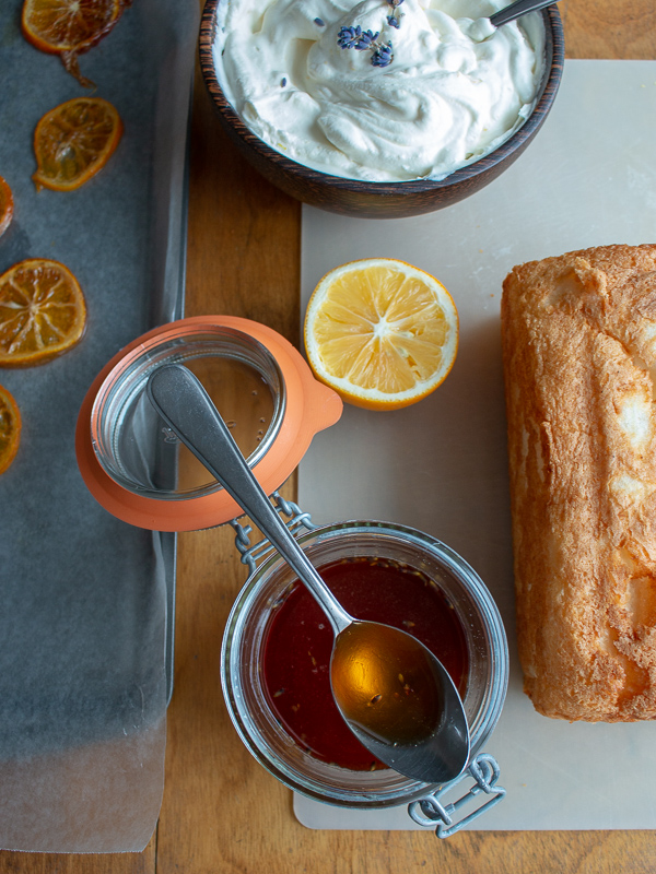 Plain angel food cake, bowl of coconut whipped topping and lavender honey ready to make the cake.